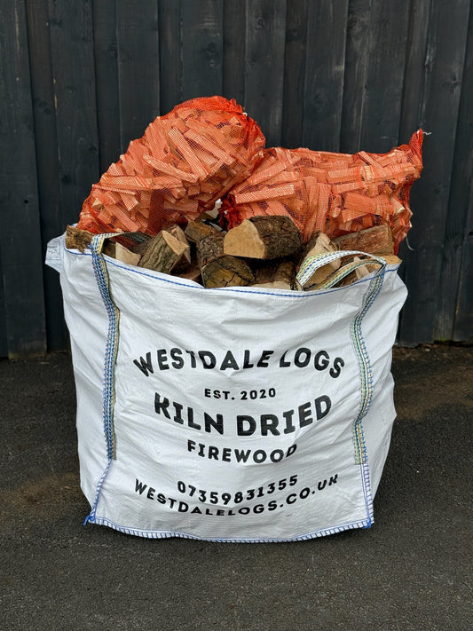 Bag of Westdale Logs kiln dried Oak firewood with visible branding and contact information. The bulk bag also has two nets of kindling placed upon it 