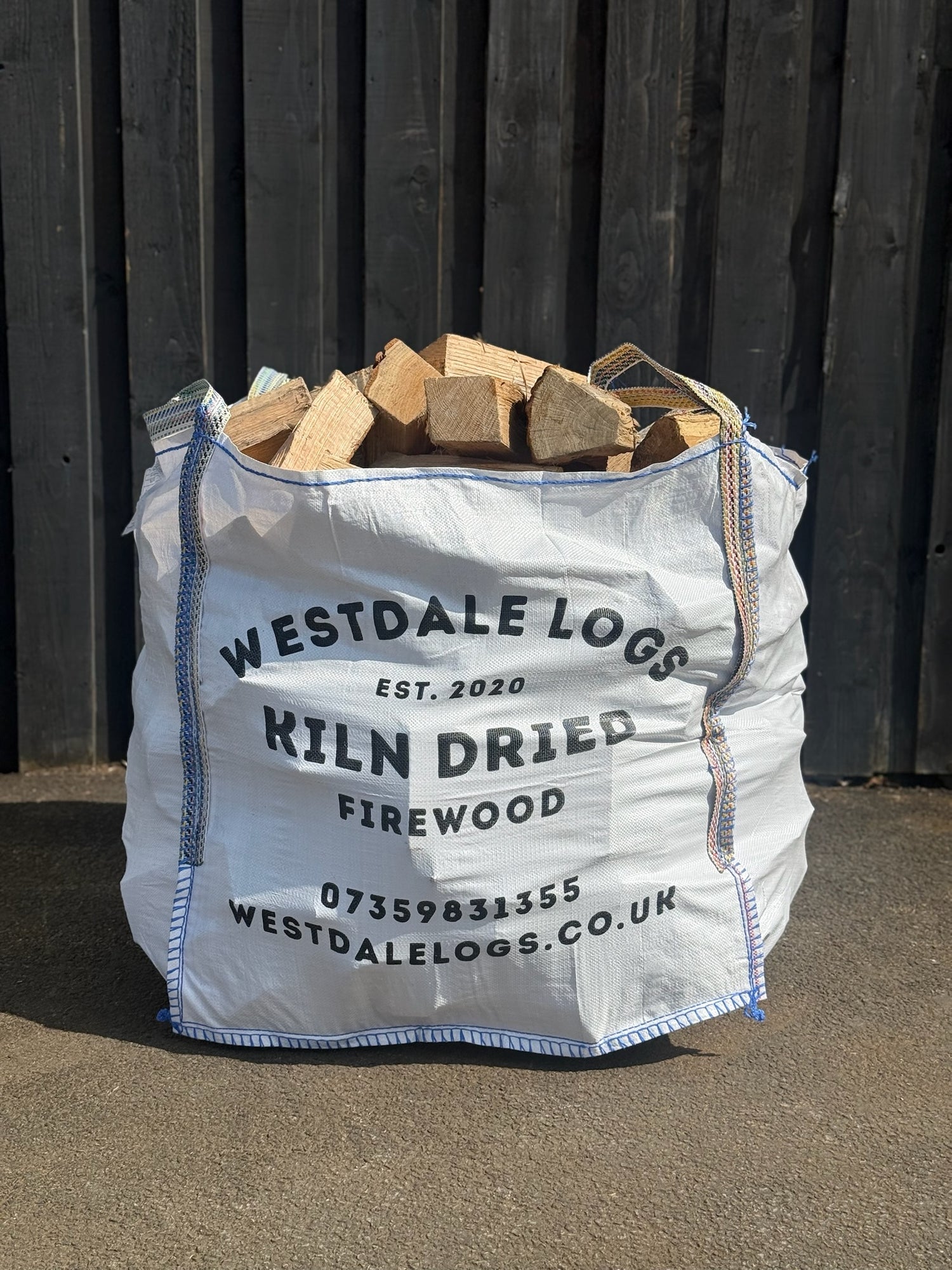 Bulk bag of kiln dried hardwood logs on concrete surface